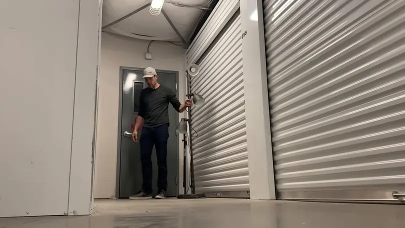 Andy Bailey stands in the doorway of an open storage unit, its roller doors pulled up